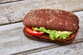 Ciabatta burger on wooden background. Royalty Free Stock Photo