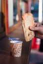 Ciabatta in hand with a cardboard cup of coffee Royalty Free Stock Photo