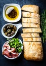 Ciabatta, pepper oil, jamon ham serrano, arugula, rosemary, slate background Royalty Free Stock Photo