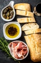 Ciabatta, pepper oil, jamon ham serrano, arugula, rosemary, slate background Royalty Free Stock Photo