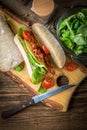 Ciabatta sandwich with arugula salad, bacon and yellow cheese