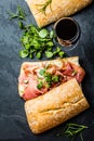 Ciabatta sandwich with jamon ham, arugula. red wine, slate background Royalty Free Stock Photo