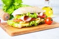 Ciabatta sandwich with lettuce, cheese, tomatoes and ham. Royalty Free Stock Photo