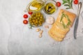 Ciabattas, olive oil in a bowl with olives, herbs, spices, garlic, pesto, parmesan and ciabatta bread on a texture background. Royalty Free Stock Photo