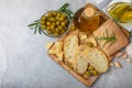 Ciabattas, olive oil in a bowl with olives, herbs, spices, garlic, pesto, parmesan and ciabatta bread on a texture background. Royalty Free Stock Photo