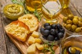 Ciabattas, olive oil in a bowl with olives, herbs, spices, garlic, pesto, parmesan and ciabatta bread on a texture background. Royalty Free Stock Photo