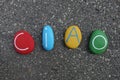 Ciao text composed with colored stones over asphalted road