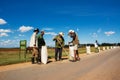 Peasants collect the rice after drying it on the asphalt