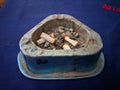 Cigarette butts and ashes in a triangular ashtray Royalty Free Stock Photo