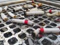 Cigarette butts in dirty ashtrays