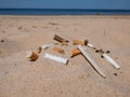 Cigarette butts in the white sand on Baltic sea beach as toxic plastic pollution in the beach sand