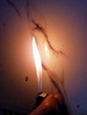 Cigarette lighter lighting flame in front of white tiles Royalty Free Stock Photo