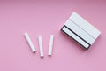 Cigarette sticks and pack on pink background