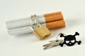 Cigarettes with chain and padlock and key with black skull on white background - Stop smoking concept Royalty Free Stock Photo