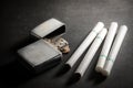 Cigarettes with old metal lighter. Royalty Free Stock Photo