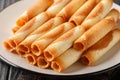 Cigarettes russes or russian cigarettes is a baked thin waffle rolls closeup on the plate. Horizontal Royalty Free Stock Photo