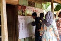 Several residents are looking at examples of election papers that stand for the general election for the new president of the