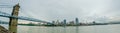 Cincinnati skyline and historic John A. Roebling suspension bridge cross Ohio River.