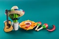 Cinco de mayo celebration concept. Cactus, maracas and sombrero hat on tilt green background