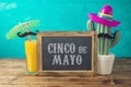Cinco de Mayo holiday background with chalkboard, Mexican cactus, party sombrero hat and orange juice Royalty Free Stock Photo