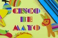Cinco de Mayo image with message added on yellow background surrounded by colorful party props with Mexican theme. Royalty Free Stock Photo