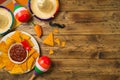 Cinco de Mayo Mexican holiday party concept with Nacho chips and sombrero hat on wooden background. Top view from above Royalty Free Stock Photo