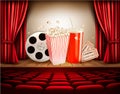 Cinema background with a film reel, popcorn, drink and tickets. Royalty Free Stock Photo