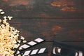 Cinema concept. Popcorn in a box, video cassette VHS and movie clapper on wooden background top view. Free space Royalty Free Stock Photo