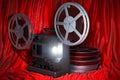 Cinema concept. Cinema projector with movie reels on the red fabric, 3D rendering Royalty Free Stock Photo