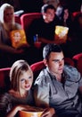 Cinema, date and couple with popcorn, watching film or eating on romantic night together. Movie, man and woman in Royalty Free Stock Photo