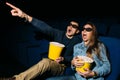 Young couple with popcorn looking horror movie in cinema