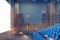 Cinema interior, blue chairs, screen, side toned