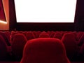 Cinema - interior of a movie theatre with empty red and black seats with white screen - mock-up screen Royalty Free Stock Photo