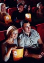 Cinema, love and couple with popcorn, watching film or eating on romantic date together. Movie night, man and woman in Royalty Free Stock Photo