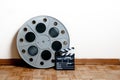 Cinema movie roll with clapper on wooden floor