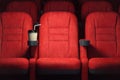 Cinema movie theater concept background. Red cinema seats and coffee or cola paper cup in empty theater