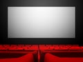 Cinema movie theatre with red seats and a blank white screen Royalty Free Stock Photo