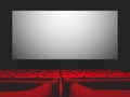 Cinema movie theatre with red seats and a blank white screen Royalty Free Stock Photo