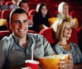 Cinema, portrait and happy couple with popcorn, watching film and romantic date together. Movie night, man and woman in Royalty Free Stock Photo