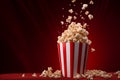 A cinema red background with delicious homemade popcorn in striped bucket cups