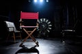 cinema reel, clapperboard, and directors chair in spotlight Royalty Free Stock Photo