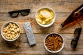 Cinema and TV whatching with beer, crumbs, chips and pop corn wooden background top view