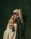 Medieval little girl as a lady with a pearl earring on dark studio background. Concept of comparison of eras, childhood