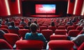 Cinema wide screen and people in red chairs in the cinema hall. Blurred People silhouettes watching movie performance