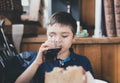 Cinematic Happy young boy drinking glass of cold drink, Portrait Child  sitting in cafe or coffee shop drinking soda or soft drink Royalty Free Stock Photo