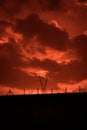 Scary sunset, with red sky and clouds, after storm. Power pylons and industrial fences in devastated landscape. B Evil environment