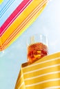 Cinematic image with glass of whiskey over summer blue sky background. Vacation, happiness, summer vibes and ad concept