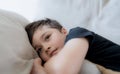 Cinematic portrait Happy young boy lying on sofa looking out with smiling face,Positive Child resting in living room with bright Royalty Free Stock Photo