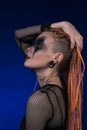 Cinematic portrait of informal woman with colored braids hairdo and horror black stage make-up