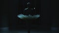 Ballerina rehearses in dark theater lobby at night